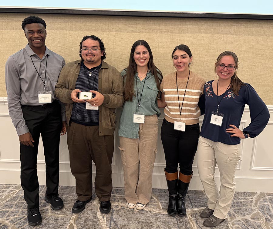 Image shows student presenters at conference receiving awards.